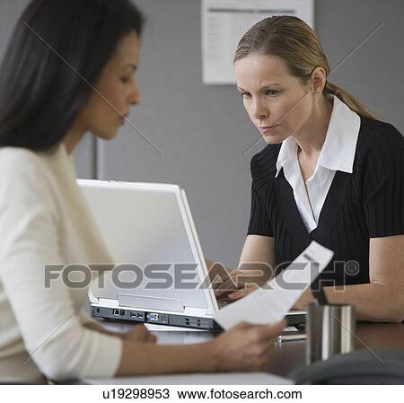 Stock Image - Multi-ethnic businesswomen working in office. Fotosearch