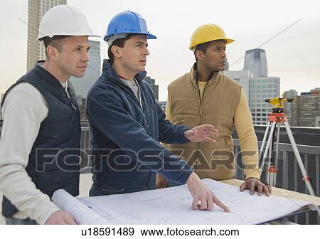 Multi-ethnic construction workers with blueprints View Large Photo Image Stock Photo - Multi-ethnic construction workers with blueprints. Fotosearch