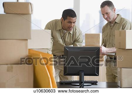 Multi-ethnic delivery men looking at computer View Large Photo Image Stock Image - Multi-ethnic delivery men looking at computer. Fotosearch