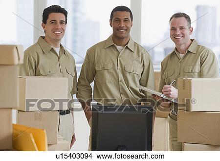Multi-ethnic delivery men next to computer View Large Photo Image Picture - Multi-ethnic delivery men next to computer. Fotosearch