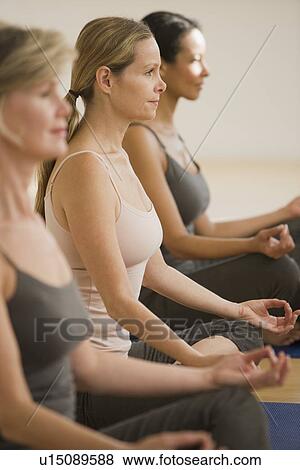 Multi-ethnic women practicing yoga View Large Photo Image Stock Photo - Multi-ethnic women practicing yoga. Fotosearch
