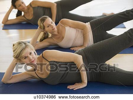 Multi-ethnic women practicing yoga View Large Photo Image Stock Photograph - Multi-ethnic women practicing yoga. Fotosearch