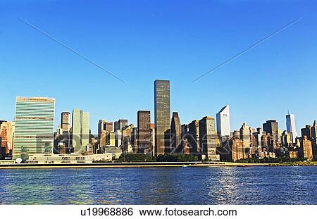 Stock Photograph - New York City skyline along water. Fotosearch