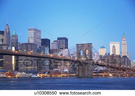 Stock Image - New York City skyline and Brooklyn Bridge at dusk. Fotosearch