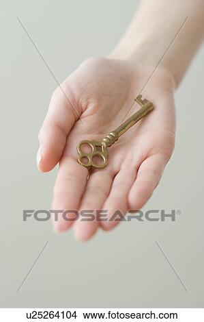 Picture - Old fashioned key in woman’s hand. Fotosearch