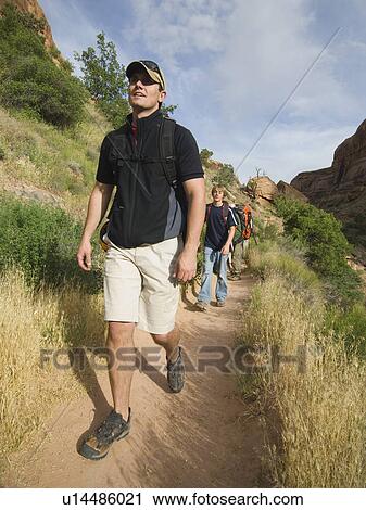 Stock Image - People hiking in desert. Fotosearch