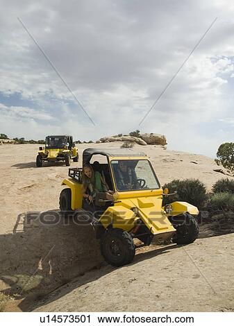 Stock Image - People in off-road vehicles on rock formation. Fotosearch