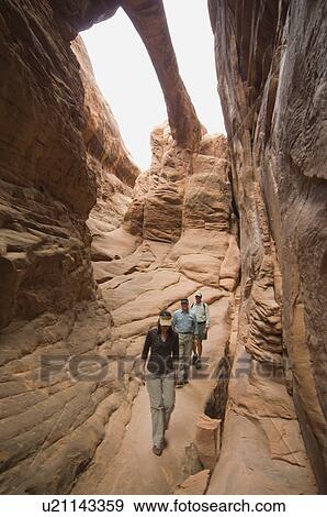 Stock Photo - People looking up at rock formations. Fotosearch