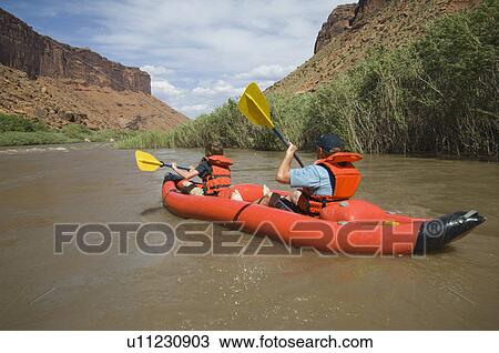 Stock Image - People paddling in raft. Fotosearch