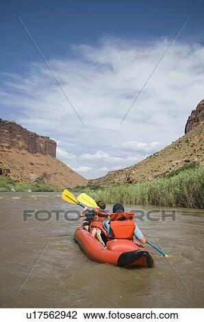 Stock Image - People paddling in raft. Fotosearch