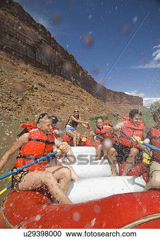 Stock Image - People paddling in raft. Fotosearch