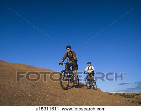 Stock Image - People riding mountain bikes. Fotosearch