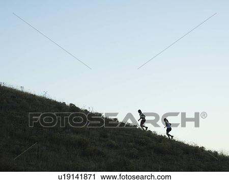 Stock Image - People running up mountain, Salt Flats, Utah, United States. Fotosearch