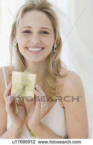 Stock Image - Portrait of bride holding gift. Fotosearch