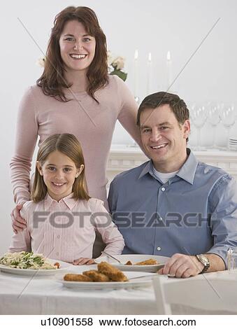Stock Photo - Portrait of family at dinner table. Fotosearch