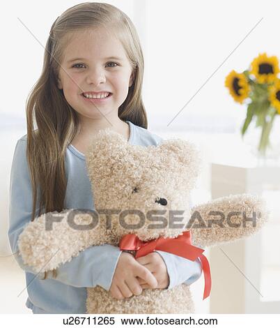 Stock Photography - Portrait of girl hugging teddy bear. Fotosearch
