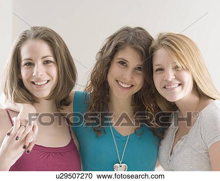 Stock Image - Portrait of teenage girls hugging. Fotosearch