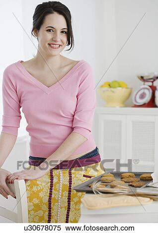 Stock Photography - Portrait of woman baking cookies. Fotosearch