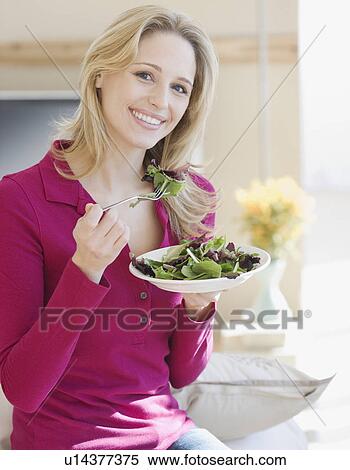 Stock Photography - Portrait of woman eating salad. Fotosearch