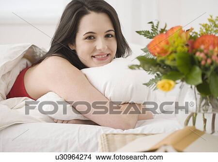 Portrait of woman laying in bed View Large Photo Image Picture - Portrait of woman laying in bed. Fotosearch