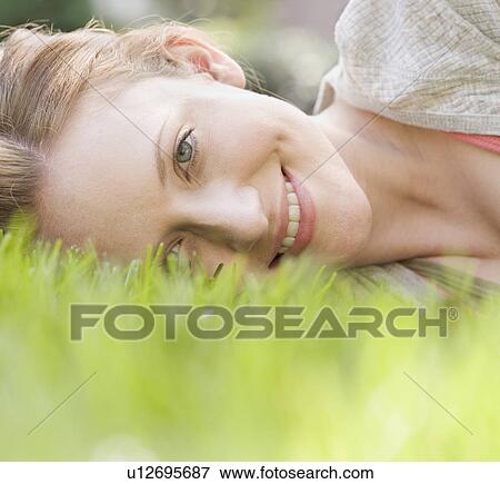 Portrait of woman laying in grass View Large Photo Image Stock Photo - Portrait of woman laying in grass. Fotosearch