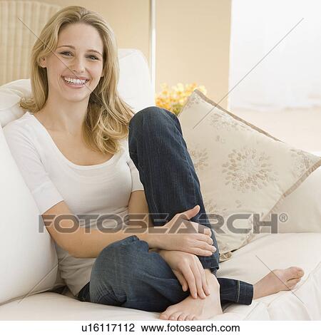 Portrait of woman sitting on sofa View Large Photo Image Stock Image - Portrait of woman sitting on sofa. Fotosearch
