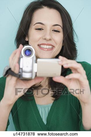 Stock Photo - Portrait of woman using video camera. Fotosearch