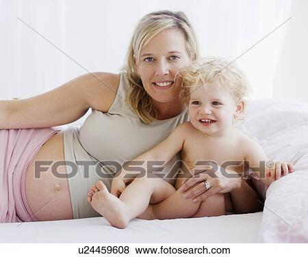 Pregnant mother hugging child View Large Photo Image Stock Photo - Pregnant mother hugging child. Fotosearch