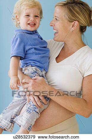 Pregnant mother hugging child View Large Photo Image Stock Photo - Pregnant mother hugging child. Fotosearch