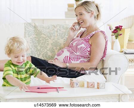 Stock Photo - Pregnant mother talking on telephone. Fotosearch