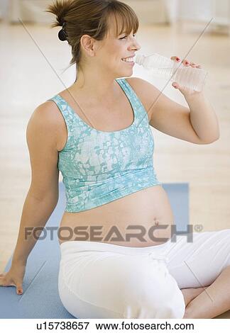 Pregnant woman drinking water View Large Photo Image Stock Photo - Pregnant woman drinking water. Fotosearch