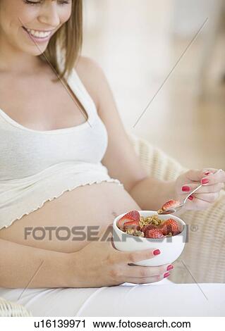 Pregnant woman eating cereal View Large Photo Image Stock Image - Pregnant woman eating cereal. Fotosearch