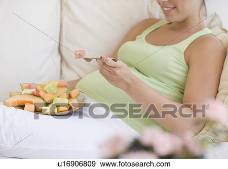 Pregnant woman eating fruit View Large Photo Image Stock Photo - Pregnant woman eating fruit. Fotosearch