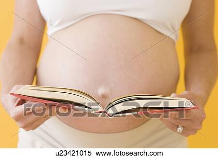Stock Photography - Pregnant woman holding open book. Fotosearch