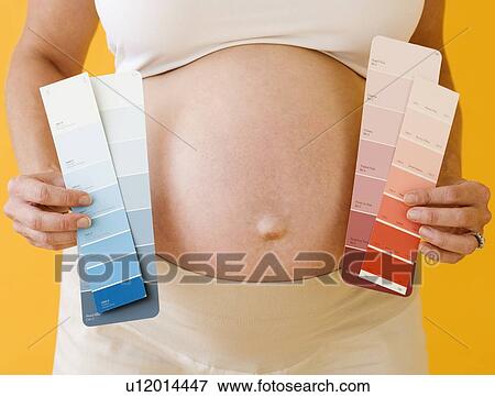 Pregnant woman holding paint swatches View Large Photo Image Stock Photo - Pregnant woman holding paint swatches. Fotosearch