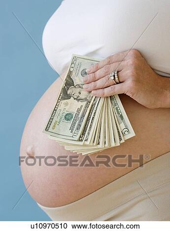 Pregnant woman holding stack of money View Large Photo Image Stock Image - Pregnant woman holding stack of money. Fotosearch