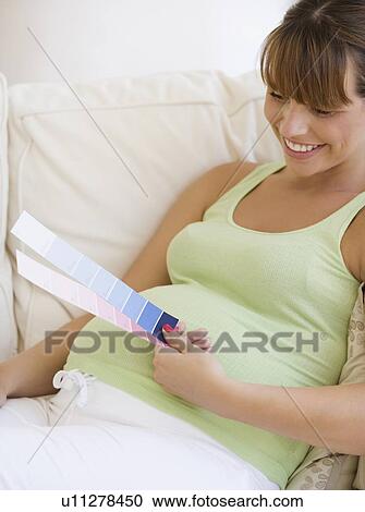 Pregnant woman looking at paint swatches View Large Photo Image Stock Image - Pregnant woman looking at paint swatches. Fotosearch