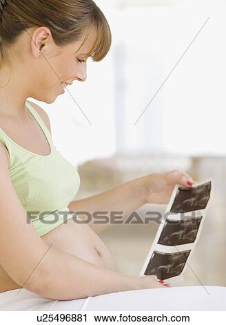 Pregnant woman looking at ultrasound printout View Large Photo Image Stock Image - Pregnant woman looking at ultrasound printout. Fotosearch