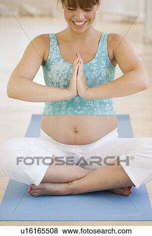 Stock Photo - Pregnant woman practicing yoga. Fotosearch