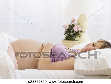 Pregnant woman sleeping in bed View Large Photo Image Stock Photo - Pregnant woman sleeping in bed. Fotosearch