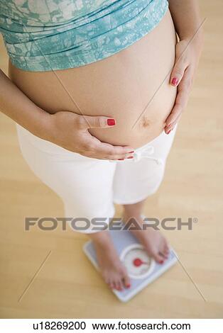 Pregnant woman standing on scale View Large Photo Image Stock Image - Pregnant woman standing on scale. Fotosearch