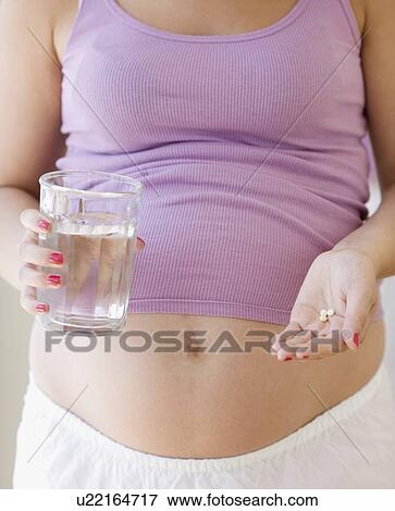 Pregnant woman taking vitamins View Large Photo Image Stock Photo - Pregnant woman taking vitamins. Fotosearch