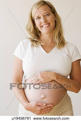 Stock Image - Pregnant woman with hands on belly. Fotosearch