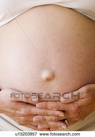 Pregnant woman with hands on belly View Large Photo Image Stock Photo - Pregnant woman with hands on belly. Fotosearch