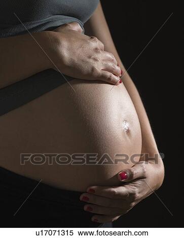 Stock Photography - Pregnant woman with hands on belly. Fotosearch