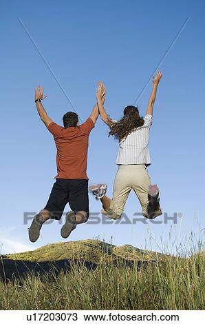 Rear view of couple jumping, Utah, United States View Large Photo Image Stock Image - Rear view of couple jumping, Utah, United States. Fotosearch