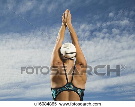 Rear view of female swimmer with arms raised, Utah, United States View Large Photo Image Stock Photography - Rear view of female swimmer with arms raised, Utah, United States. Fotosearch