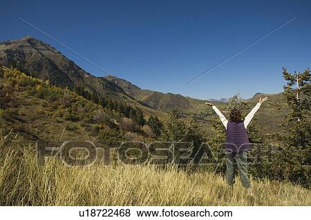 Rear view of woman with arms raised, Utah, United States View Large Photo Image Stock Photo - Rear view of woman with arms raised, Utah, United States. Fotosearch