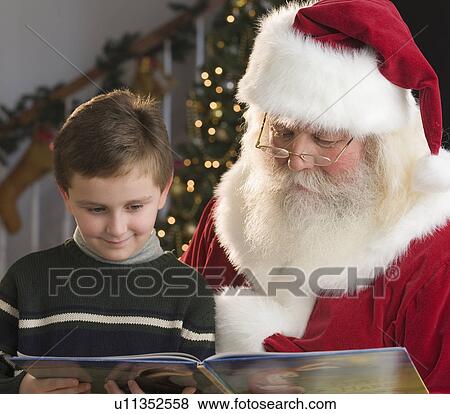 Santa Claus and boy reading book View Large Photo Image Stock Photo - Santa Claus and boy reading book. Fotosearch