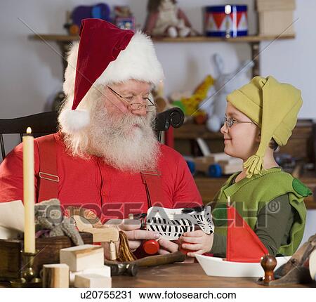 Stock Image - Santa Claus and elf with toys. Fotosearch
